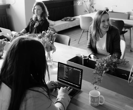 People at a desk with a laptop