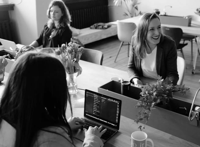 People at a desk with a laptop